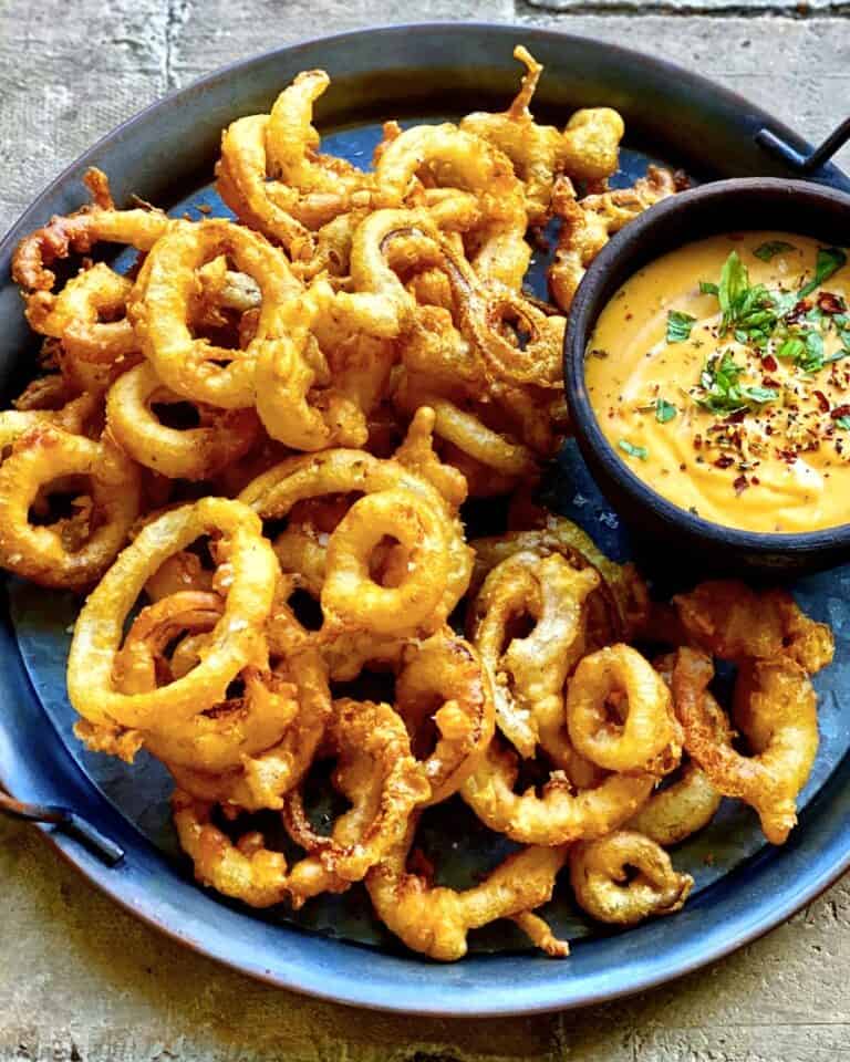 Friterede løgringe - hjemmelavede indbagte løg serveret med cheddar dip