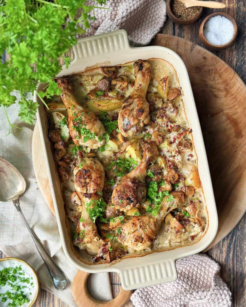 Kyllingelår i fad med kartofler, bacon og champignoner i cremet sauce.
