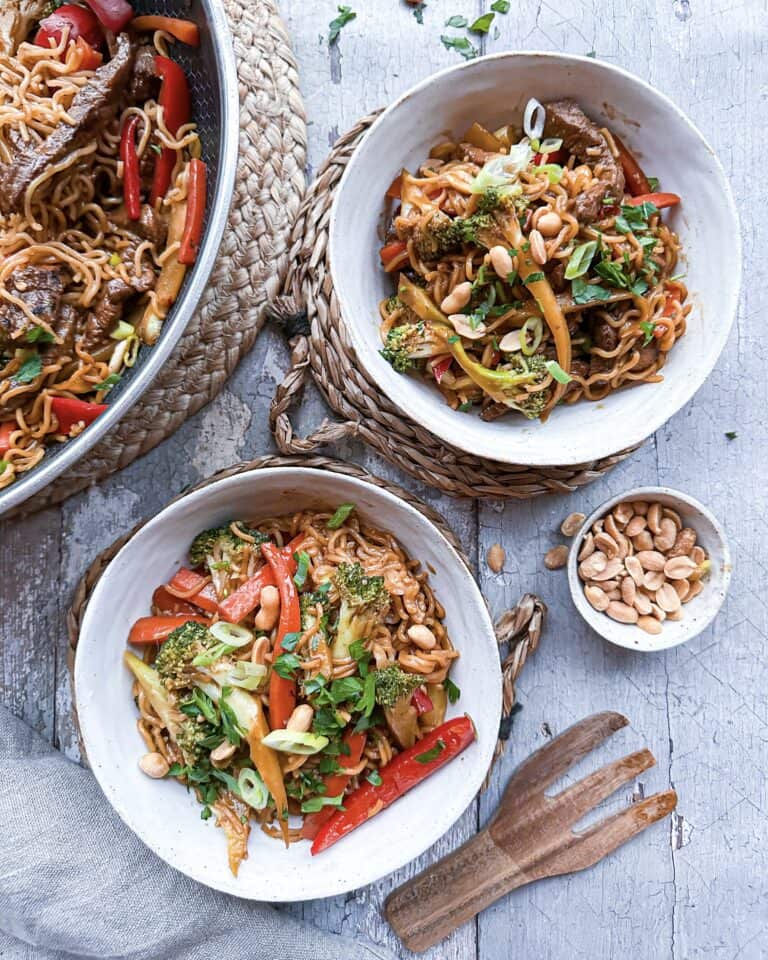 Wokret med lynmarineret oksekød i strimler, nudler og sprøde grøntsager tilberedt i wok eller stegepande.