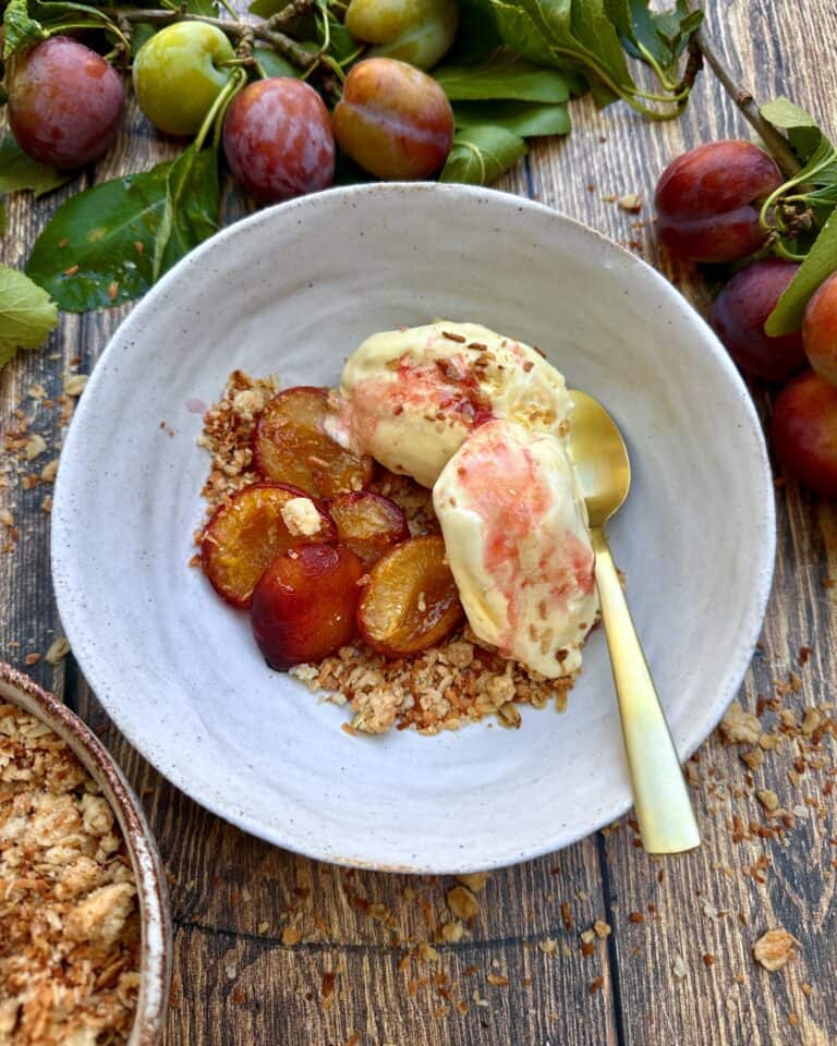 Bagte blommer serveret med crumble og vaniljeis