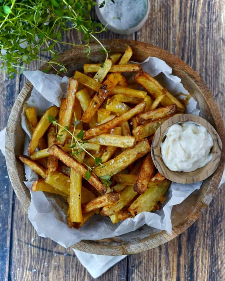 Pommes frites i airfryer serveret i træskål med salt og mayonnaise.