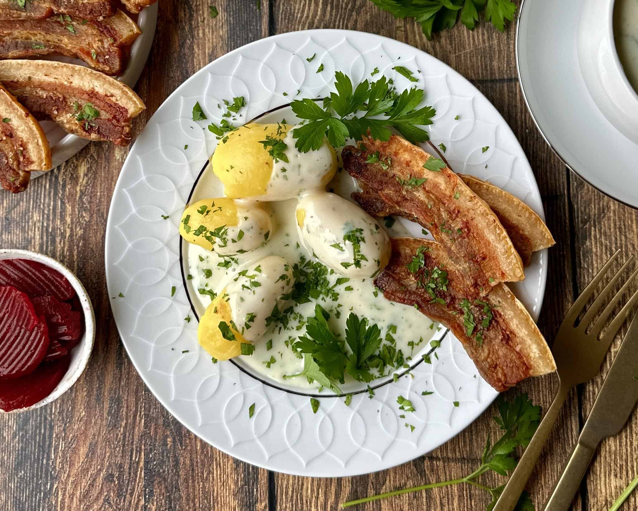 Stegt flæsk stegt i airfryer og serveret med kogte kartofler og persillesovs.