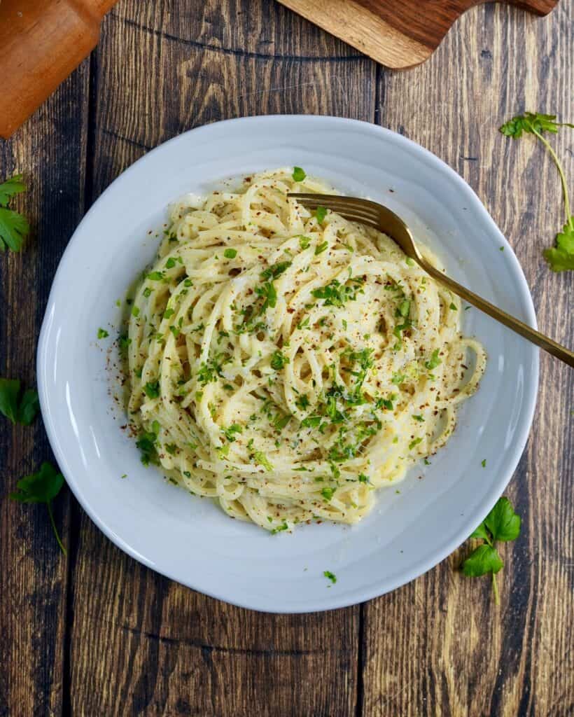 Pasta Alfredo - spaghetti vendt i sovs af smør, hvidløg, fløde, parmesan og friskkværnet peber. Fintsnittet persille og parmesan som drys.