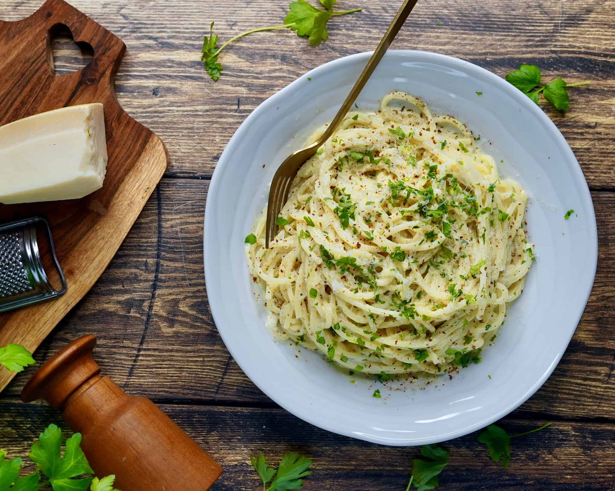 Pasta Alfredo - spaghetti vendt i sovs af smør, hvidløg, fløde, parmesan og friskkværnet peber. Fintsnittet persille og parmesan som drys.