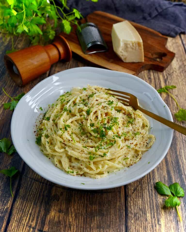 Pasta Alfredo - spaghetti vendt i sovs af smør, hvidløg, fløde, parmesan og friskkværnet peber. Fintsnittet persille og parmesan som drys.