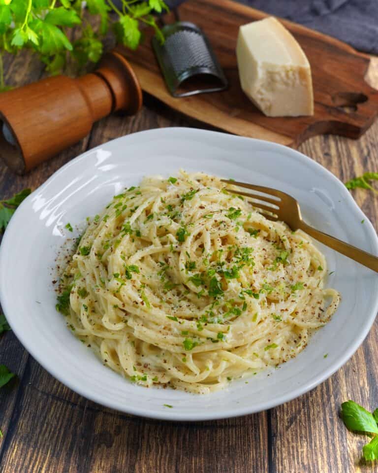Pasta Alfredo - spaghetti vendt i sovs af smør, hvidløg, fløde, parmesan og friskkværnet peber. Fintsnittet persille og parmesan som drys.
