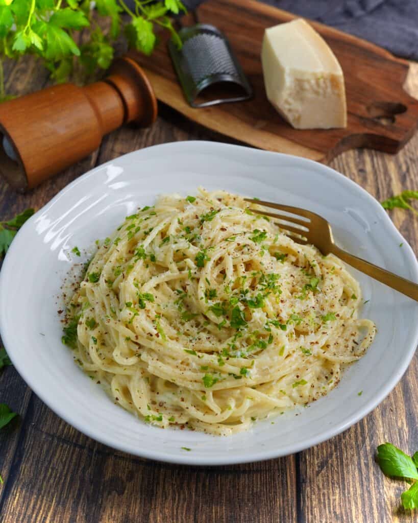 Pasta Alfredo - spaghetti vendt i sovs af smør, hvidløg, fløde, parmesan og friskkværnet peber. Fintsnittet persille og parmesan som drys.