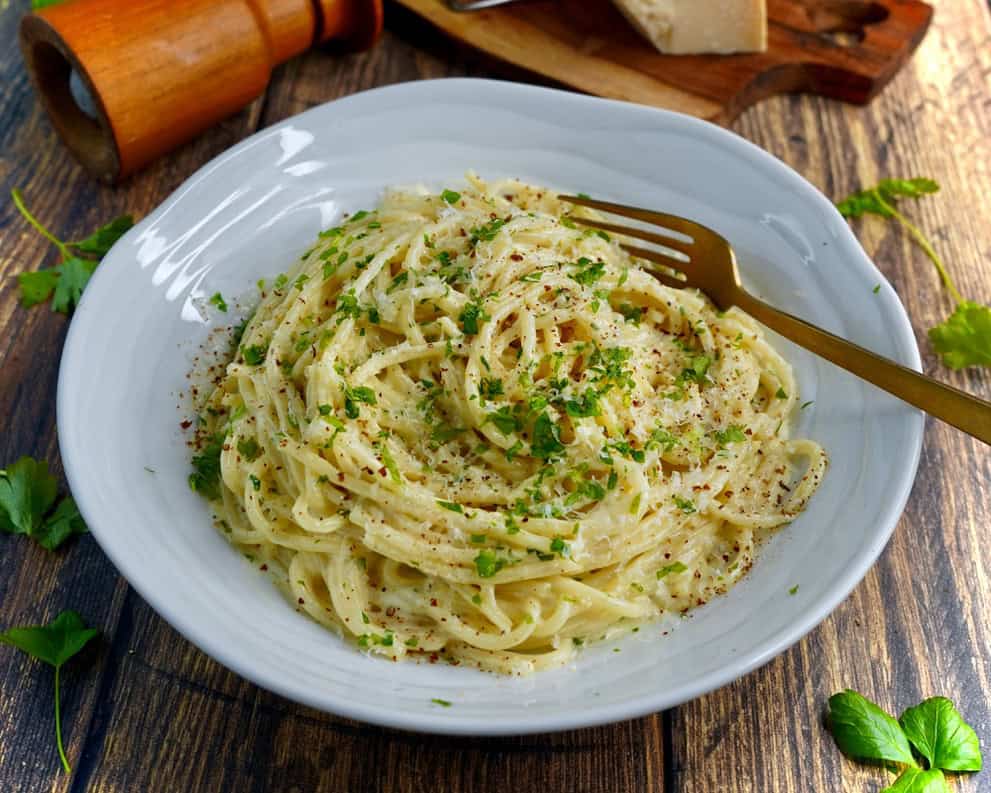 Pasta Alfredo - spaghetti vendt i sovs af smør, hvidløg, fløde, parmesan og friskkværnet peber. Fintsnittet persille og parmesan som drys.