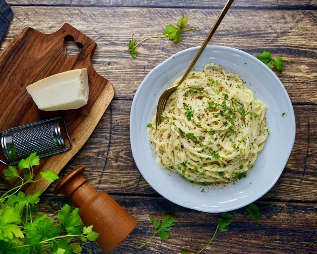 Pasta Alfredo - spaghetti vendt i sovs af smør, hvidløg, fløde, parmesan og friskkværnet peber. Fintsnittet persille og parmesan som drys.