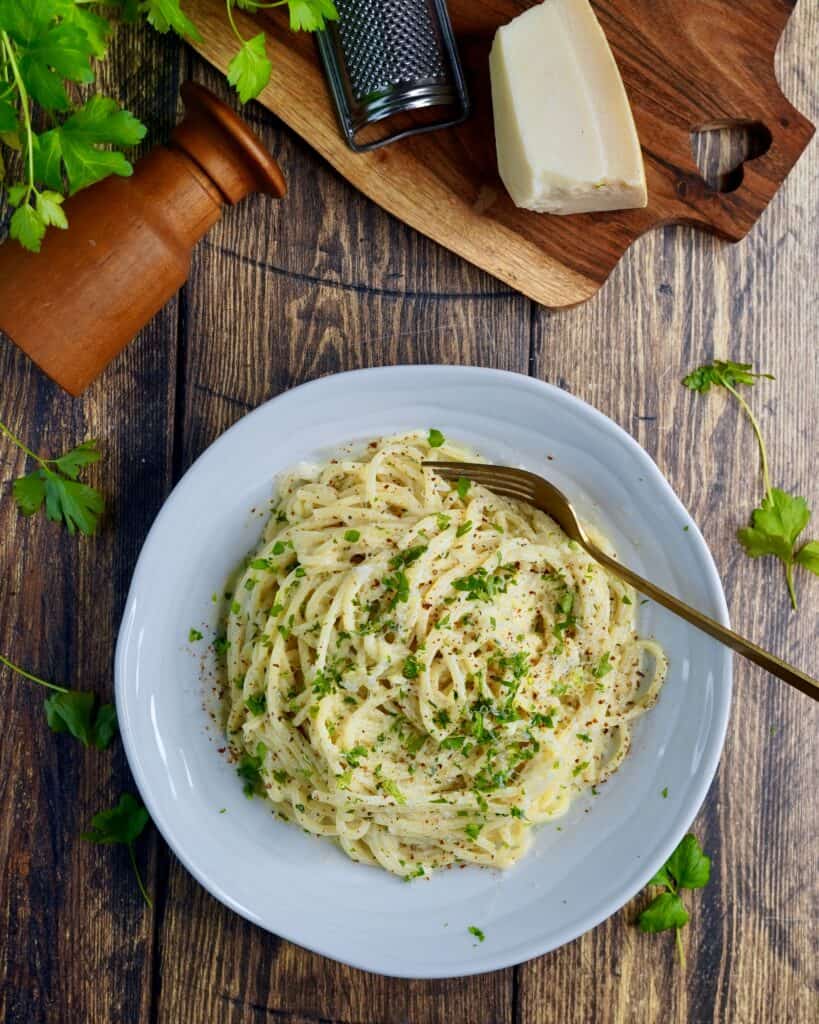 Pasta Alfredo - spaghetti vendt i sovs af smør, hvidløg, fløde, parmesan og friskkværnet peber. Fintsnittet persille og parmesan som drys.