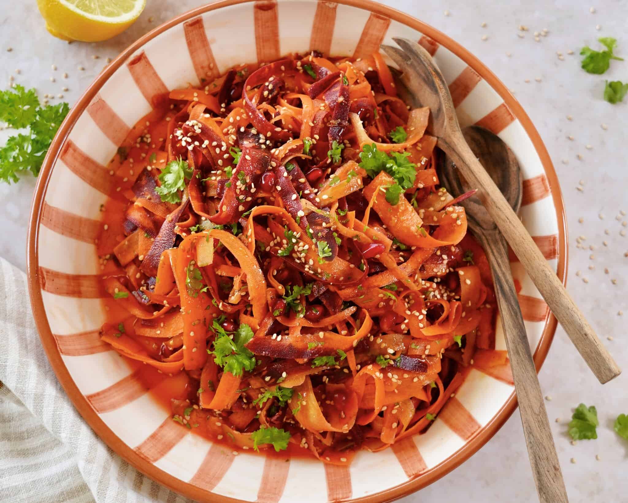 Asiatisk gulerodssalat med granatæblekerner, sesamfrø og lækker dressing.