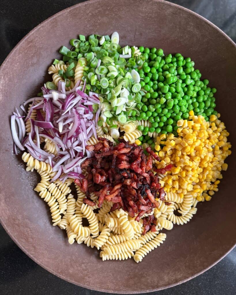 Ingredienser til pastasalat med grøntsager og sprødstegt bacon