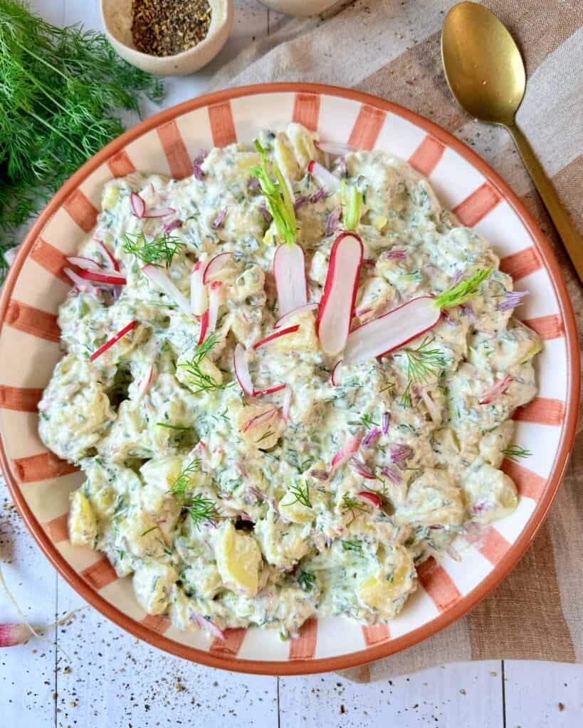 Cremet kartoffelsalat med agurk og radiser i creme fraichedressing med dild og purløg.