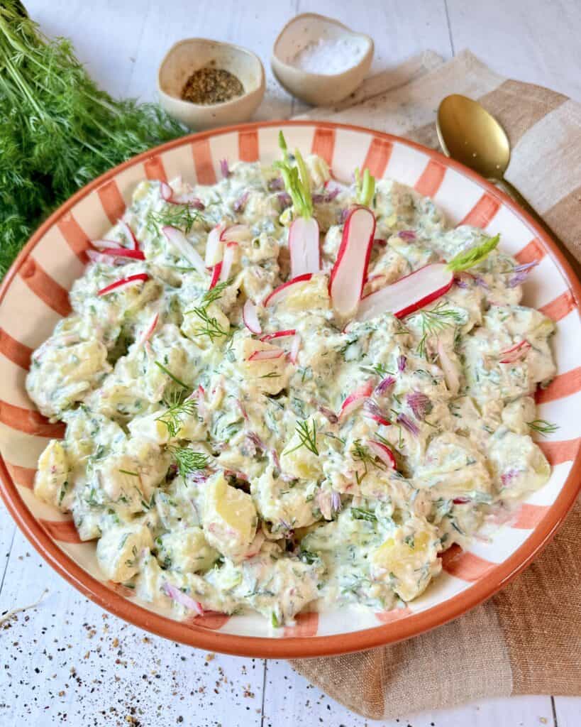 Cremet kartoffelsalat med agurk og radiser i creme fraichedressing med dild og purløg.