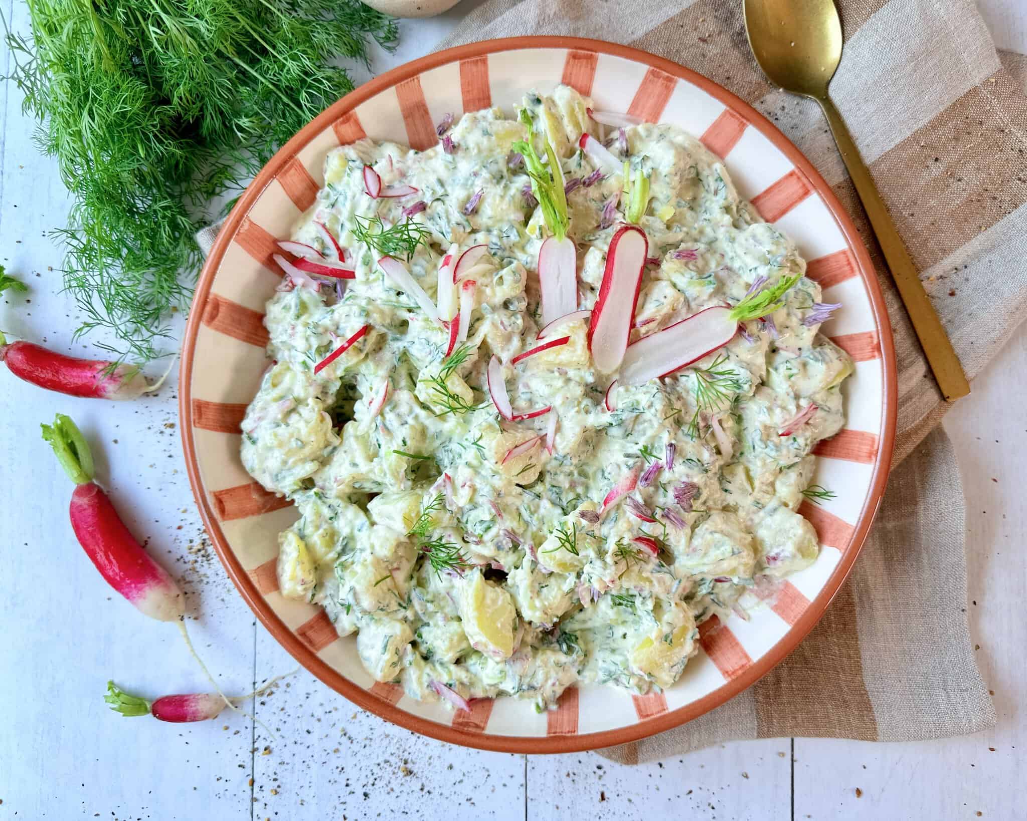 Cremet kartoffelsalat med agurk og radiser i creme fraichedressing med dild og purløg.