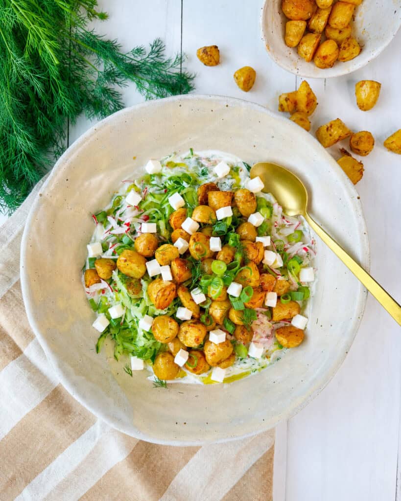Græsk kartoffelsalat med små bagte kartofler, feta, agurk, radiser og cremet tzatziki.
