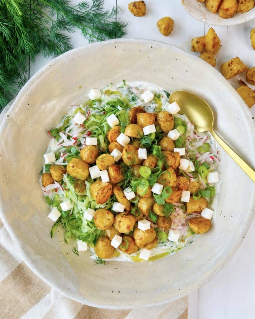 Græsk kartoffelsalat med små bagte kartofler, feta, agurk, radiser og cremet tzatziki.