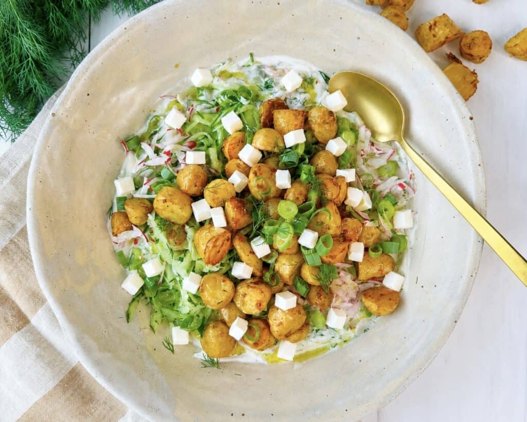 Græsk kartoffelsalat med små bagte kartofler, feta, agurk, radiser og cremet tzatziki.