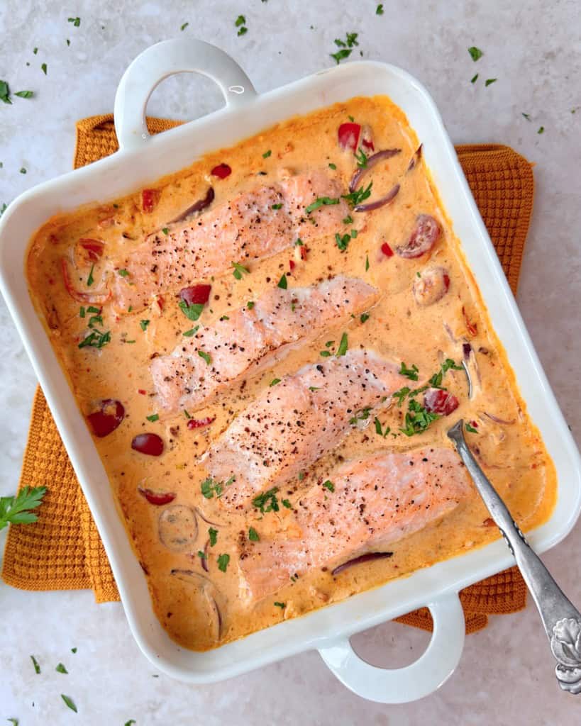 Laks i fad med cremet peberfrugtsauce.