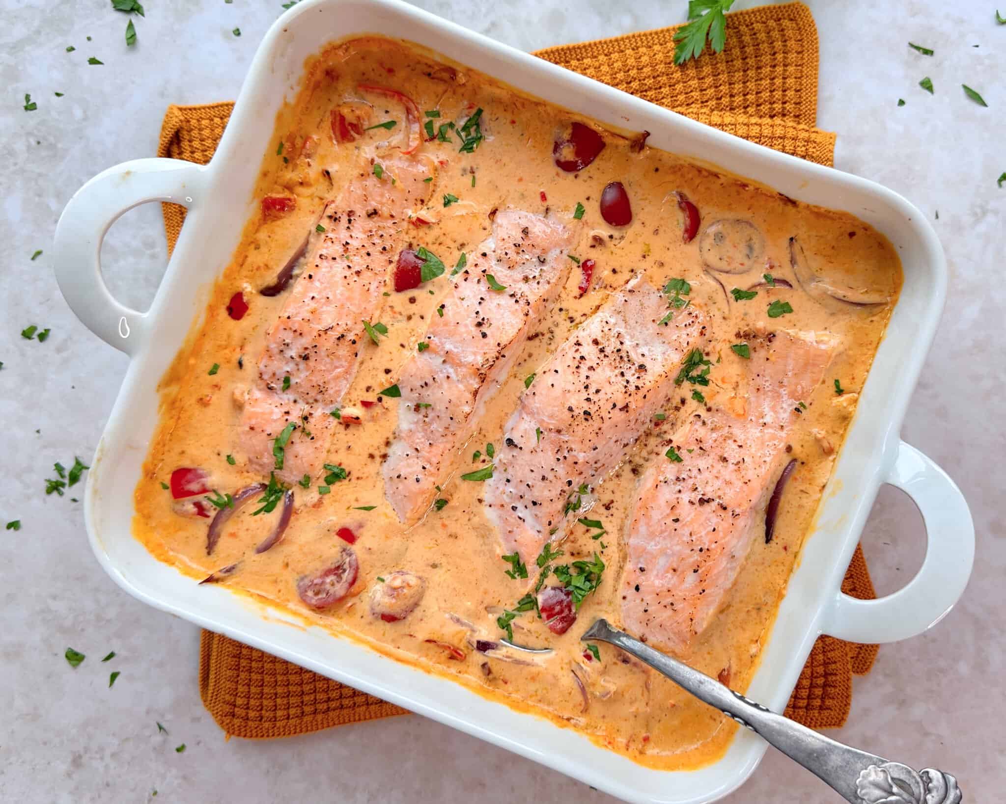 Laks i fad med cremet peberfrugtsauce.