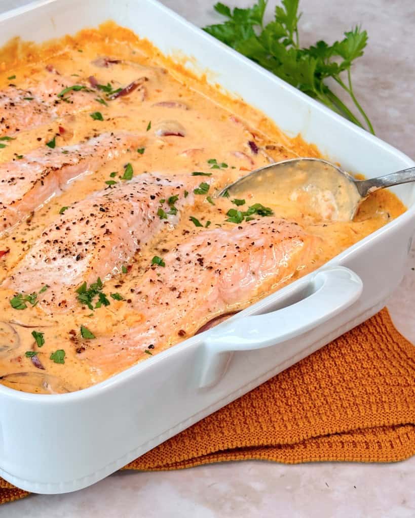 Laks i fad med cremet peberfrugtsauce.